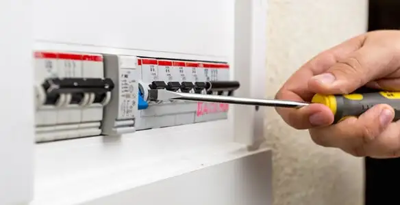 electrical panel upgrade service showing technician adjusting circuit breakers during system upgrade in Waltham, MA