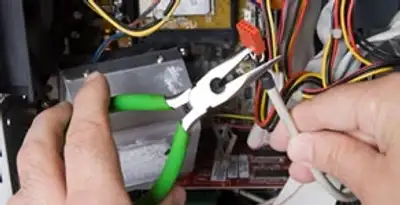Licensed electrical contractor performing electrical repair with tools in Weston, MA