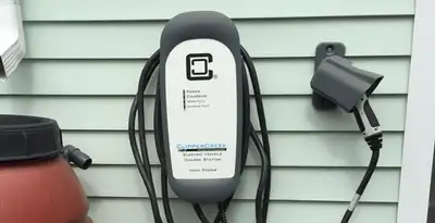 Outdoor electric vehicle charger installation on residential wall in Waltham, MA